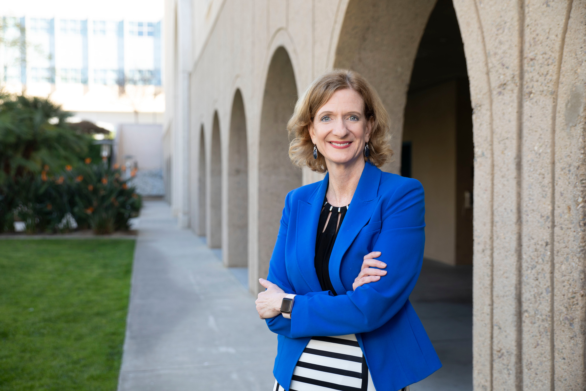 President Neufeldt standing arms crossed in blue jacket